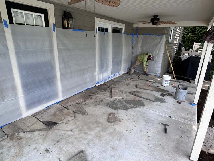 Completed wet-laid natural flagstone patio beneath a covered outdoor living area